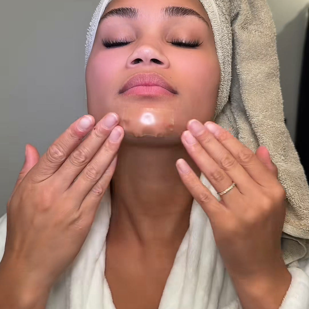 Woman pressing a wide hydrocolloid patch onto her chin