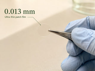 Macro view of the 0.013 mm Zero-Fit film held in tweezers